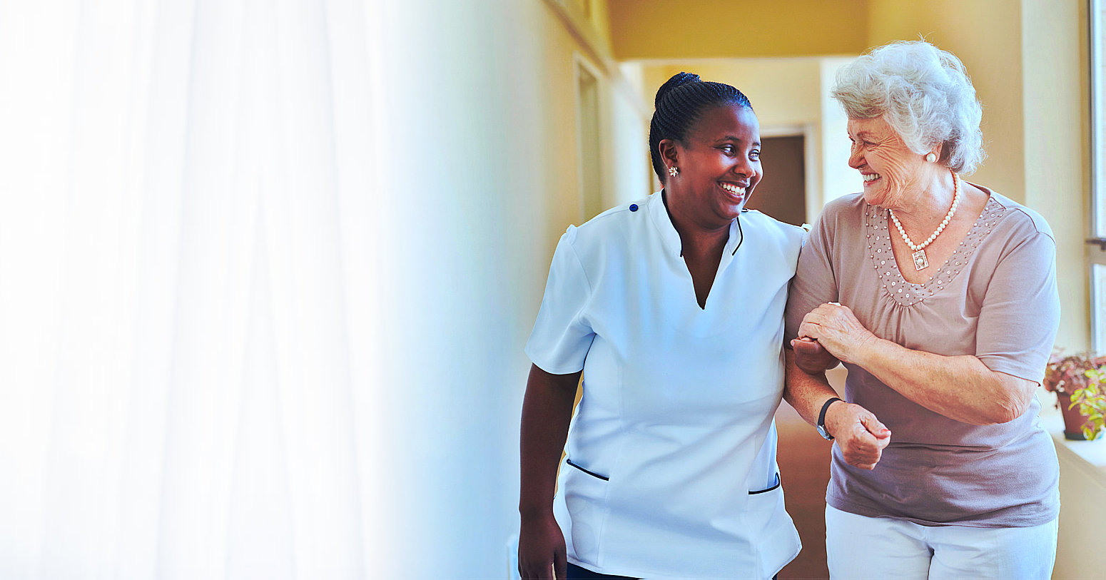 elderly woman and caregiver smiling