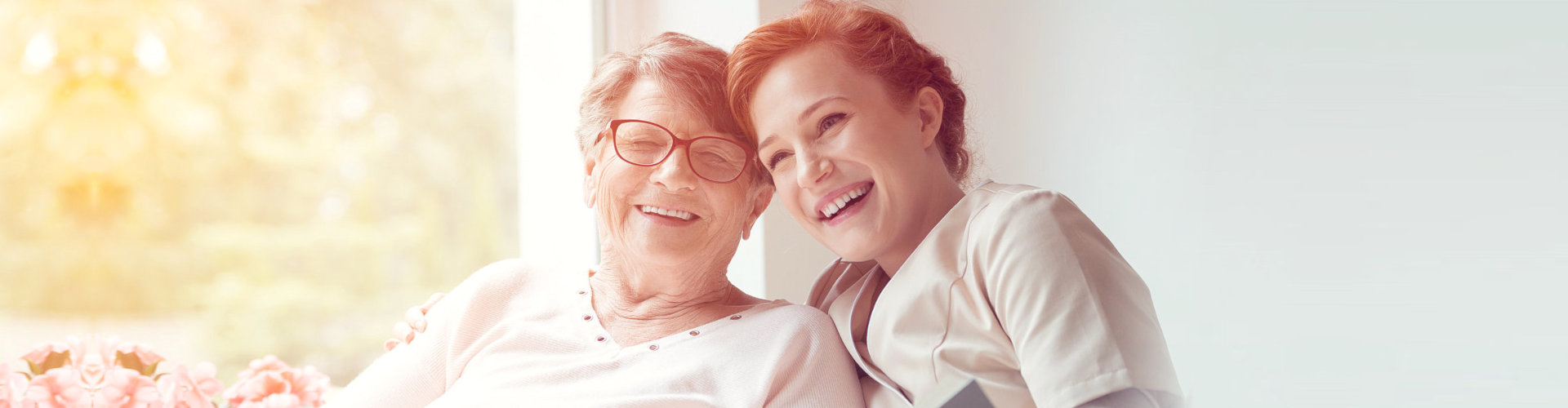 senior woman and caregiver smiling